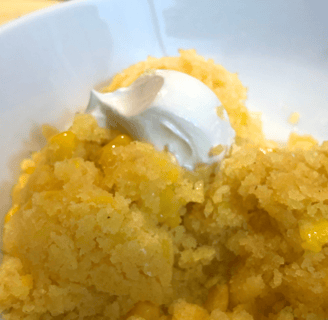 A bowl of moist Mexican corn cake topped with thick sour cream