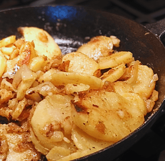 iron skillet with fried potatoes and onions