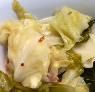 bowl of southern cabbage with smoked meat and red pepper flakes in broth