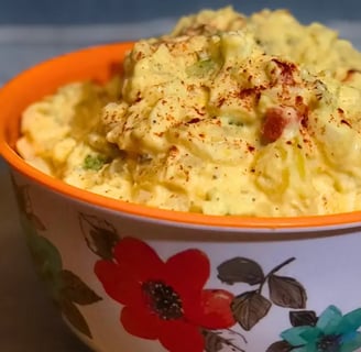 flowered bowl filled with southern potato salad on table.