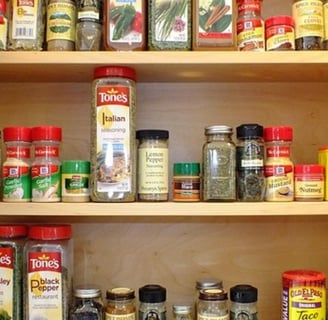 a large variety of spices in the kitchen cabinet.