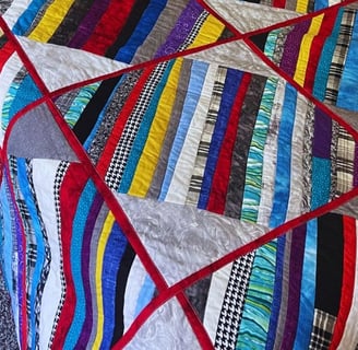 colorful quilt with red sashes and multicolored strips made for my son