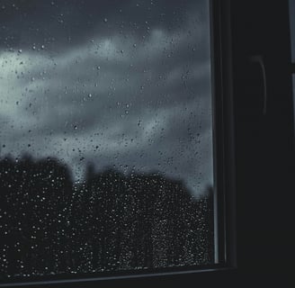 View of dark storm clouds through a window during a summer thunderstorm