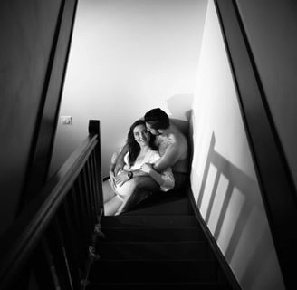 couple assis dans l'escalier pour une photo de grossesse