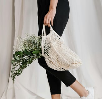 a woman holding a net net baguet bag