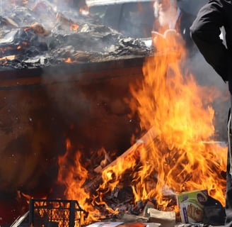 A man standing in front of a burning trash