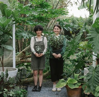 two women standing in a garden with plants
