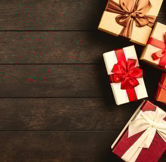 a bunch of gift boxes with bows on a wooden table