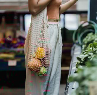 a woman in a white top and a bag of fruit and vegetables