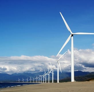 a wind turbine on a beach with a blue sky