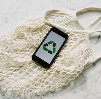 a cell phone with recycle logo on top of a net bag
