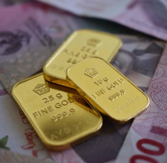 a pile of indonesian rupiah with a gold bar on top of them