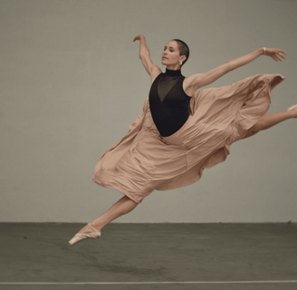 a woman dancing in a dress and a black top.