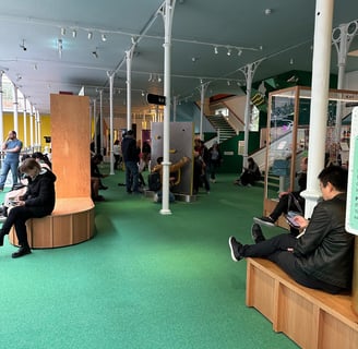 Parents on devices at the V&A Young Museum, London, UK