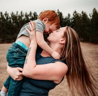 Duluth Mama spinning toddler around and kissing him on the nose