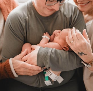 Both grandmas on either side of new mama in hospital bracelets