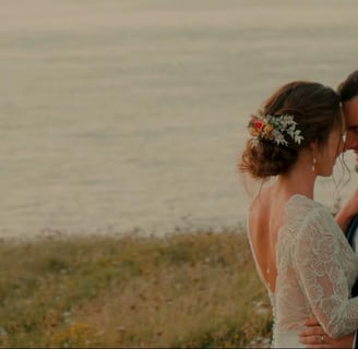 Moment complice des mariés enlacés au bord de la mer, capté par une vidéaste de mariage