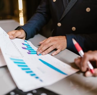 Two members of a team analysing a spreadsheet containing business data and statistics