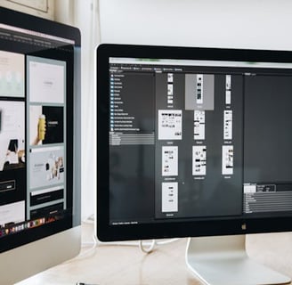 Two monitors displaying mockups for a website design
