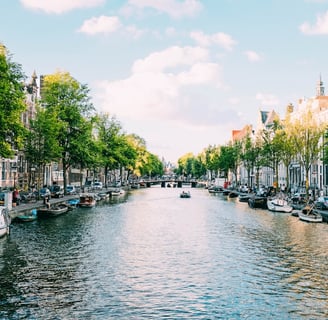 a canal with boats and people walking on it