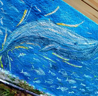 détail d'une peinture murale représentant une baleine et un banc de poissons
