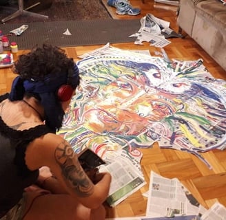 Naía découpe la composition réalisée sur papier journal avant d'aller la coller dans les rues de Belo Horizonte
