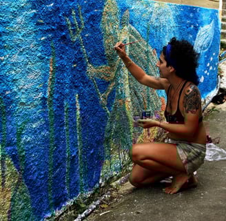 Naía peignant une peinture murale représentant un fond marin avec poseidon, ue baleine