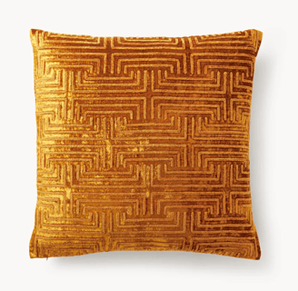 a gold coloured cushioned pillow with a maze pattern
