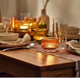 a table setting with a candle lite up in the middle of the table