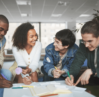 A group of people talking about a group project around a table.
