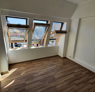 a renovated room with a window and a window with a view of a city
