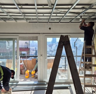 a construction worker fixing the electrical conduits in the ceiling