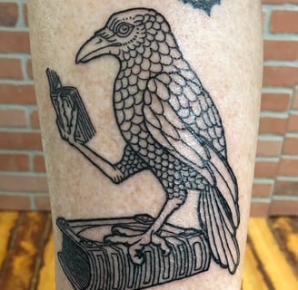 Reading raven standing on book tatttoo