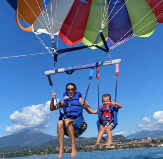 a women and a girl are parasailing in the water