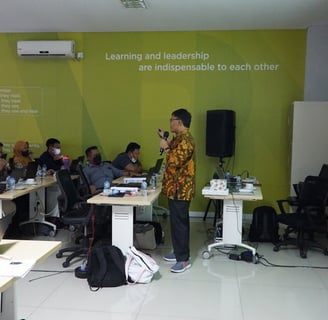 a man standing in front of a classroom with a speaker