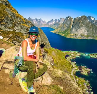 Hiker enjoying summer view from Reinebringen trail above Reine near Maritime Munchies in Lofoten