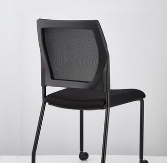 V137 black mesh-back chair, side angle with visible frame and castors