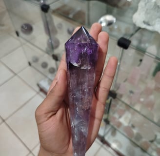 a person holding a large purple crystal point crystal point point point point point point point