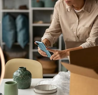 a woman in a beige shirt is holding a cell phone