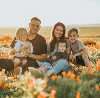 happy man and his family in a field of flowers