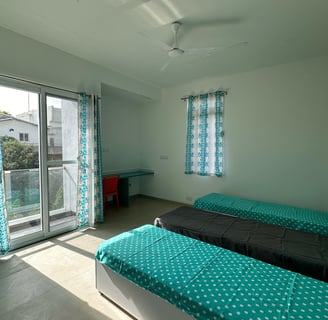Spacious twin-sharing PG room in Banglore with a balcony, modern furniture, A/C and luxury.