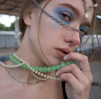 Foto de mulher usando colares de miçangas coloridas e correntes.