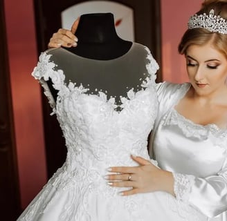 femme tient une robe de mariée sur un mannequin