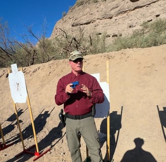 firearms instructor demonstrating shooting tactics with a blue training gun, work space