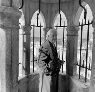 a man in a coat and hat standing in a tower