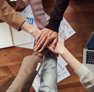 a team of managers bringing hands together in a circle