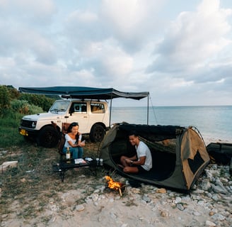 Couple enjoying a campfire and tent setup next to their Suzuki Jimny by the ocean in Okinawa | Evertrail Okinawa
