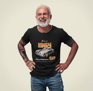 A man wearing a 'Born in 1964' t-shirt stands with his hands on his hips in a casual pose, smiling
