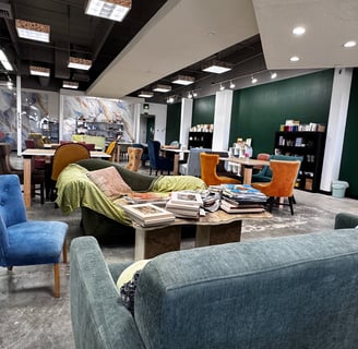 This is a photo of the interior of Clay Paper Ink. There is a variety of comfortable unique chairs. 