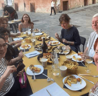 a group of people sitting at a table with food